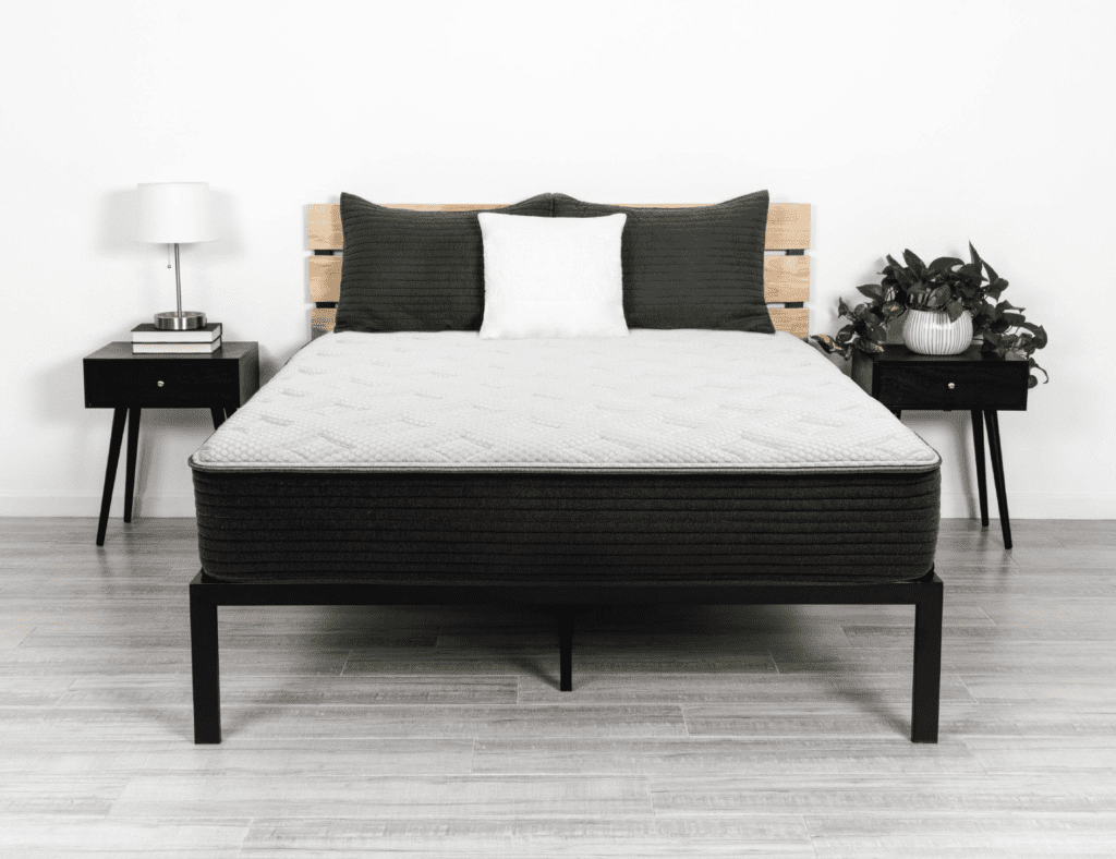 King Koil Culver Intimate Medium mattress displayed on a modern bed frame with decorative pillows, showcasing handcrafted design and premium comfort in a stylish bedroom setting.