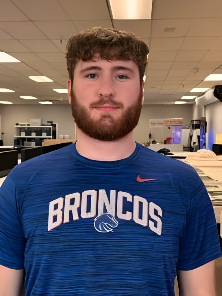 Employee at Boise Mattress wearing a blue Broncos shirt, showcasing the team spirit in a sleep-enhancing retail environment.